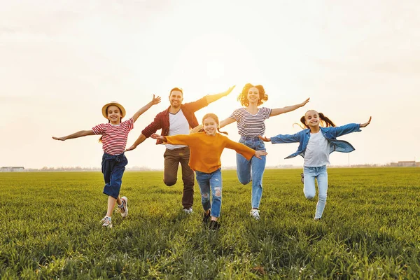 Felices Padres Jóvenes Con Hijas Ropa Casual Corriendo Con Los — Foto de Stock