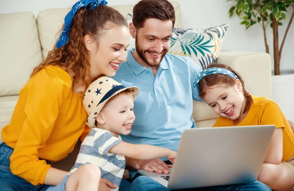 快乐的家庭 英俊的男性微笑着 女人和孩子们聚集在客厅的沙发上 一起看笔记本电脑 — 图库照片