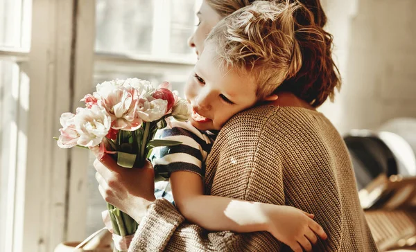 Niño Alegre Abrazando Madre Feliz Con Ramo Flores Mano Mientras —  Fotos de Stock