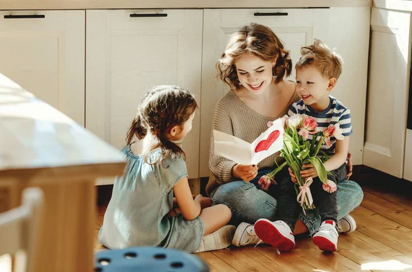 Lächelnde Junge Frau Liest Grußkarte Während Sie Mit Fröhlichen Kleinen — Stockfoto