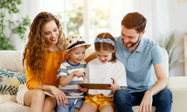 Menina Compartilhando Tablet Com Irmão Pais Sorridentes Enquanto Reúnem Todos — Fotografia de Stock