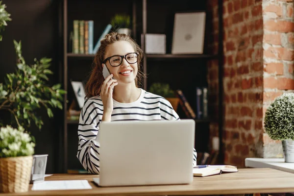 Jovem Mulher Conversando Com Cliente Smartphone Com Laptop Sentado Uma — Fotografia de Stock