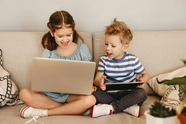 Glad Liten Flicka Bläddrar Bärbar Dator Och Yngsta Bror Spelar — Stockfoto