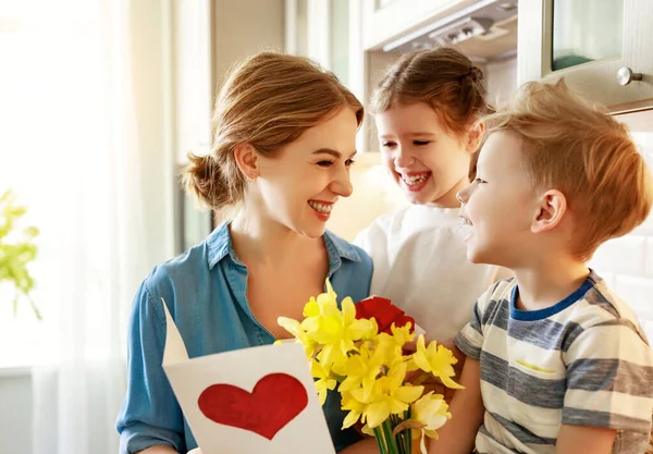 선물을 즐거운 소녀와 꽃다발을 미소를 어머니를 축하하는 카드를 — 스톡 사진