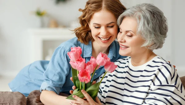 Veselý Mladý Fena Objímání Šťastný Starý Matka Dávat Kytici Tulipánů — Stock fotografie