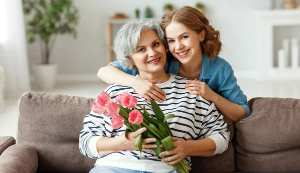 Vidám Fiatal Mosolyog Átöleli Boldog Idősebb Anya Csokor Tulipán Kezében — Stock Fotó