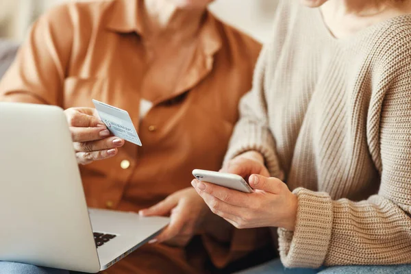 自宅でプラスチッククレジットカードでオンラインショッピング中にラップトップやスマートフォンを使用してカジュアル服のクロップ女性 — ストック写真