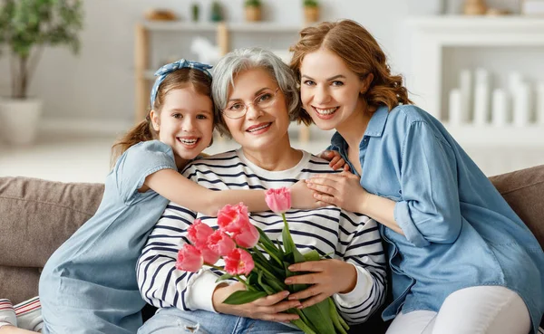 Sonriente Hembra Anciana Con Ramo Tulipanes Sentada Sofá Con Hija —  Fotos de Stock