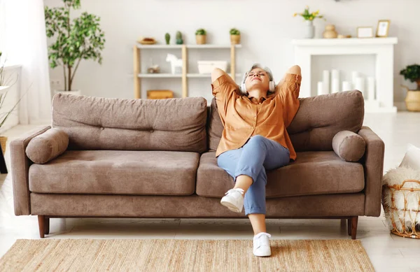 Ältere Dame Mit Kopfhörer Sitzt Auf Der Couch Und Hört — Stockfoto