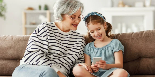 Klein Meisje Glimlachen Het Tonen Van Smartphone Aan Oudere Vrouw — Stockfoto