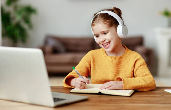 Happy Little Girl Headphones Smiling Making Notes Notepad While Communicating — Stock Photo, Image