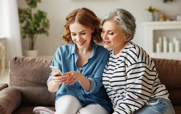 Jovem Feliz Sorrindo Compartilhando Dados Smartphone Com Mãe Sênior Enquanto — Fotografia de Stock