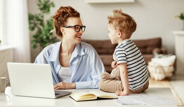 Glada Kvinnliga Entreprenör Och Liten Pojke Ler Och Skriva Laptop — Stockfoto