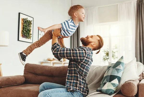Cheerful Father Sitting Sofa Throwing Delighted Little Boy While Having — Stock Photo, Image