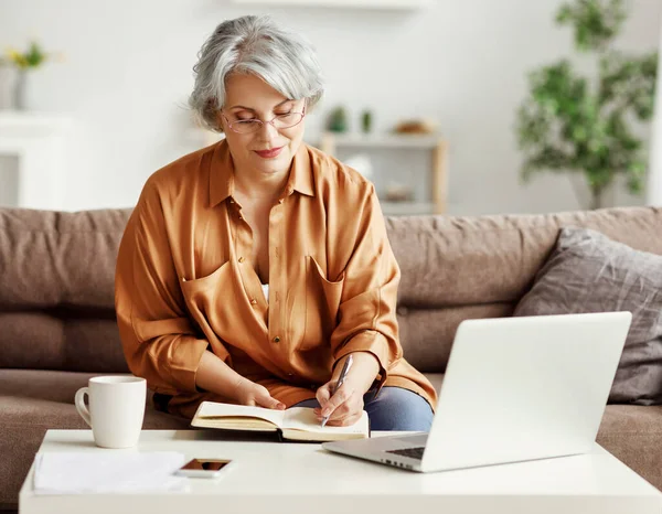 Senior Vrouw Met Laptop Notebook Terwijl Zitten Aan Tafel Werken — Stockfoto