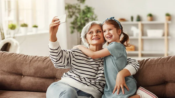 Seniorin Lächelt Und Macht Selfie Mit Fröhlichem Mädchen Während Sie — Stockfoto