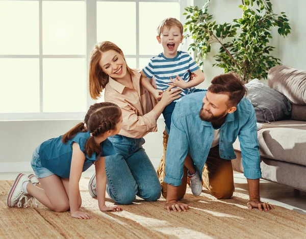明るい家族の若い男は 興奮した小さな息子にピギーバックライドを与えながら 家族と一緒に時間を過ごし 家で一緒に時間を楽しむ — ストック写真