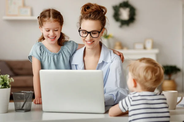 幸福的家庭一个在笔记本电脑上远程工作的自由职业者的母亲 孩子们 孩子们 孩子们 孩子们 — 图库照片