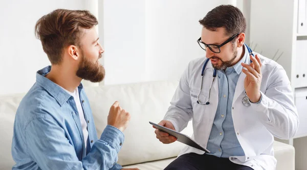 Joven Barbudo Gesticulando Hablando Con Amable Médico Masculino Mientras Está — Foto de Stock