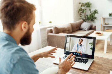 Genç bir adam internette bir doktorla görüntülü konuşma görüşmesi yapıyor.
