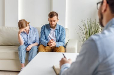 Çağdaş Clini 'yle terapist odasında koltukta oturup ağlayan kadınla konuşmaya çalışan bir adam.