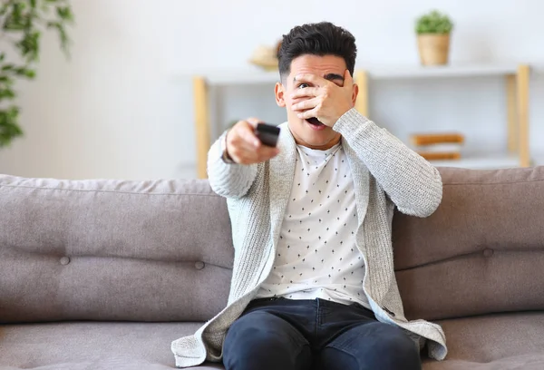 Spooked Young Man Covering Face Hand Switching Channel While Sitting — Stock Photo, Image