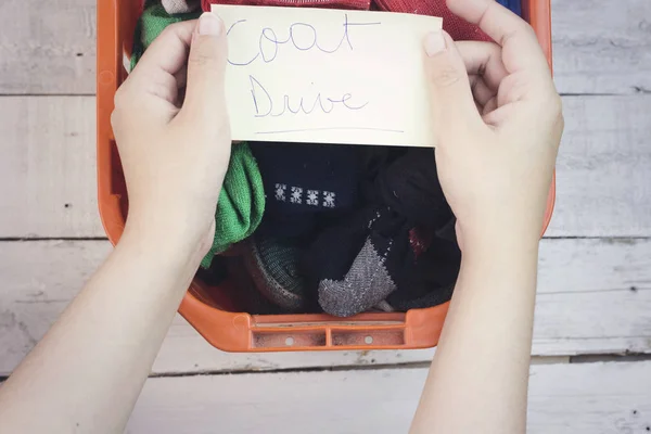 woman giving a orange clothes box for donation