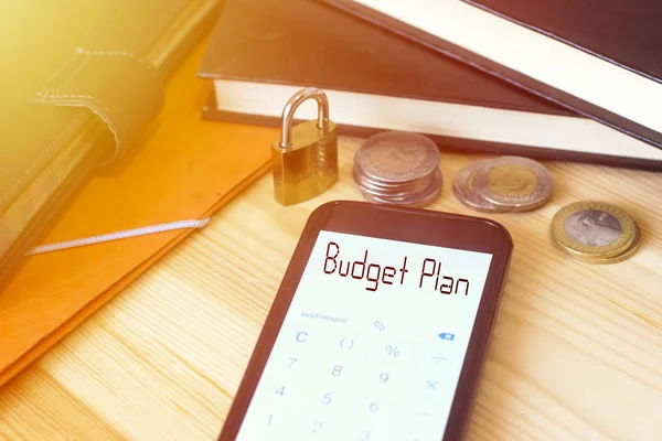 budget plan text on phone calculator with padlock and coin algeria and black book