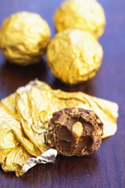 Ahşap masa altın kağıda sarılmış çikolata topları