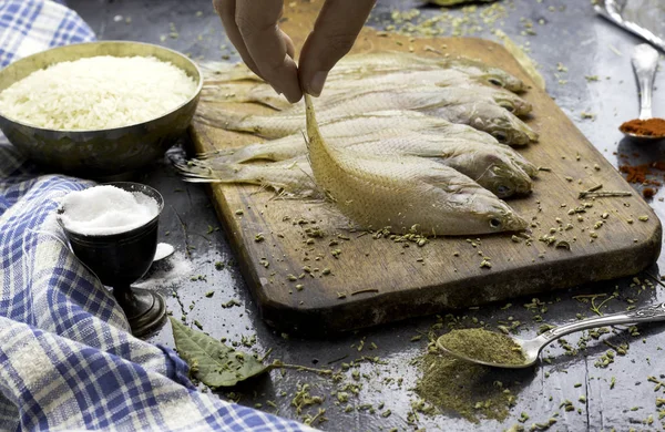 hand woman hold sole fish not baked to prepare dinner