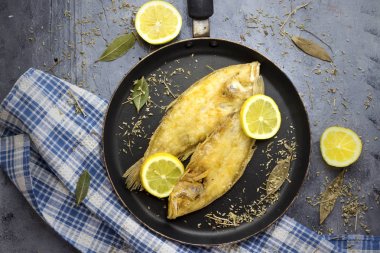lezzetli hazır tek siyah tava balık ve limon ve otlar ile dekore edilmiş