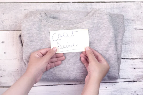 coat drive concept, holding paper with coat drive message