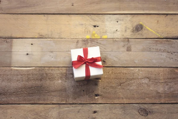Маленькая Белая Коробка Подарков Красной Лентой Деревянном Столе — стоковое фото