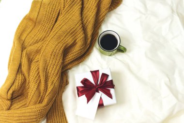 Kahve fincanı ve hediye kutusu, yatağın üstündeki boş kart, merhaba kış ve noel konsepti.