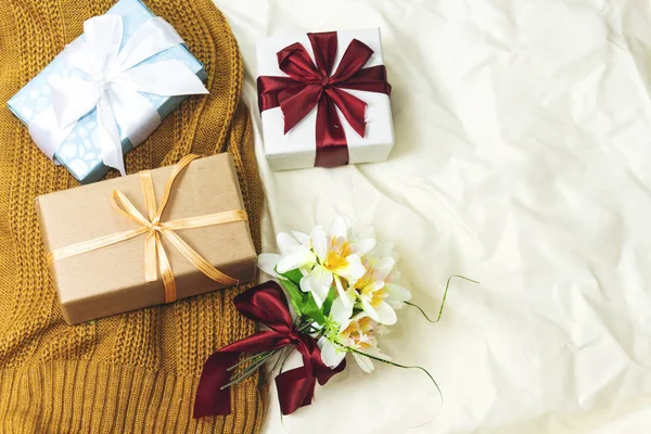 gift boxes on bed with winter scarf. holiday concept