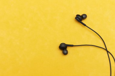 Sarı arka planda siyah kulaklıklar. Müzik benim hayat konseptimdir.