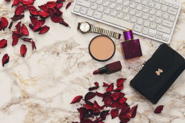 Debriyaj çantası, modern klavye, kurutulmuş çiçekler ve makyaj.