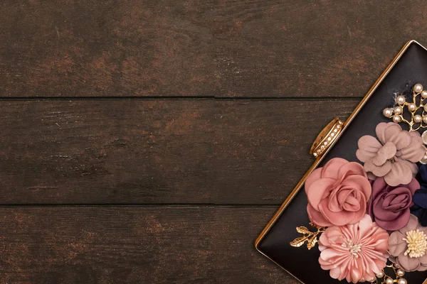 美しい女性花の黒いクラッチ 木製のテーブルの上の結婚式のバッグ — ストック写真