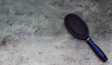 Gri arka planda şık bir saç fırçası. Kadın Saç Bakımı Aksesuarları. 