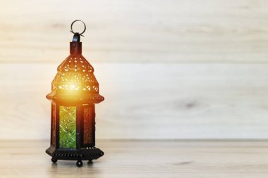 Yanan mumla süslenmiş Arapça bir fener. Bayram tebrik kartı. Müslümanların kutsal ayı için davet