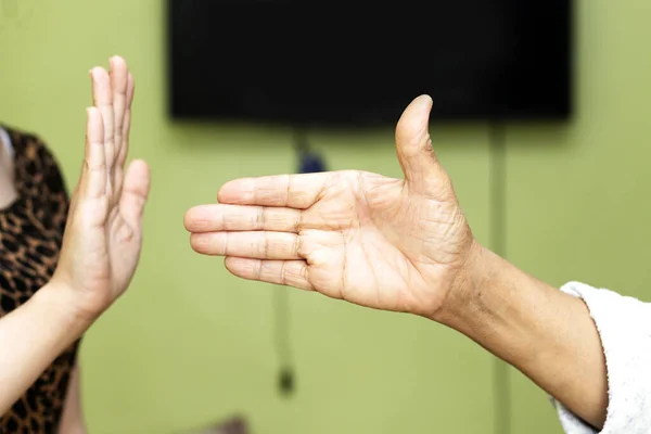 woman refusing hand shake with her friend to protect herself from coronavirus