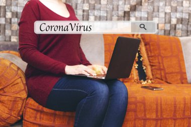 Fas usulü oturma odasında oturan genç bir kadın dizüstü bilgisayar kullanıyor ve Coronavirus konseptini araştırıyor.