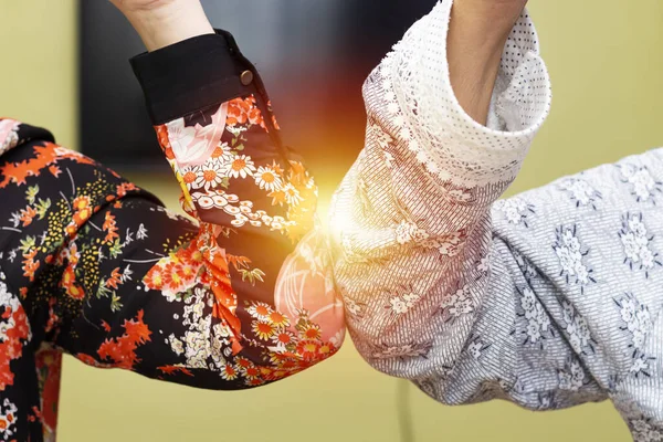 Dirsek çarpması. Kendilerini koronavirüsten korumak için karşılama romanları.