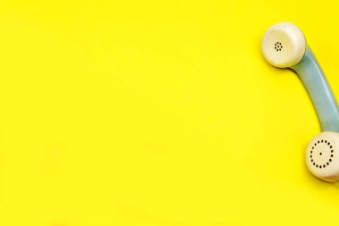 Sarı arkaplanda izole edilmiş eski eski bir telefon.