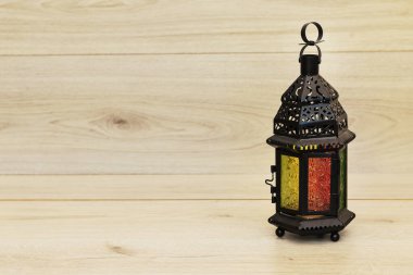 Yanan mumla süslenmiş Arapça bir fener. Bayram tebrik kartı. Müslümanların kutsal ayı için davet