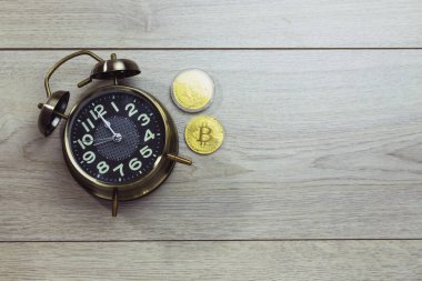 Üzerinde altın Bitcoin olan bir ofis masasının çalar saati. Kripto para birimine yatırım yapmak için bir süre belirle