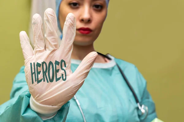 Female doctor wearing mask showing heroes on stop sign with her hand.novel coronavirus - 2019-nCoV concept