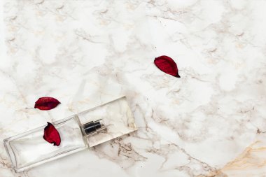 şeffaf cam parfüm şişesi ve kurumuş çiçekler.