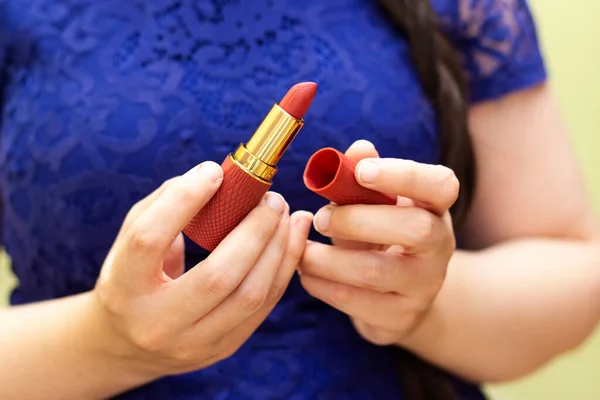 Closeup of woman testing new lipstick different color on her hand