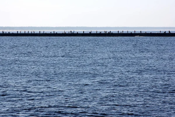Viele Angler stehen auf einem Maulwurf in der Ostsee in der Bolderaja Riga und fangen Fische — Stockfoto